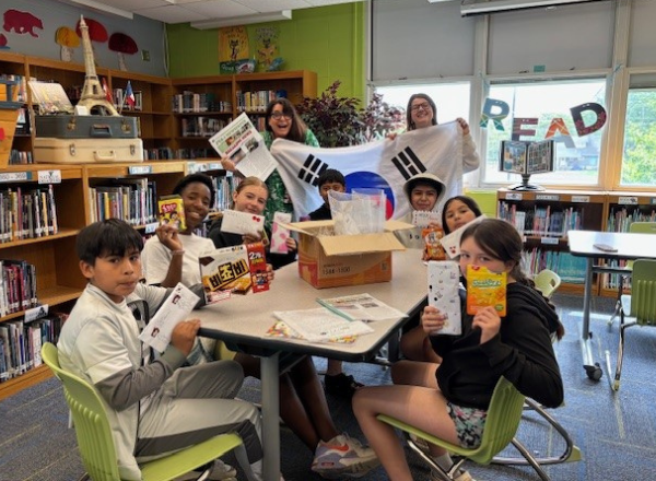  Pipkin students open their letters from South Korea & pose with a South Korea flag and other gifts